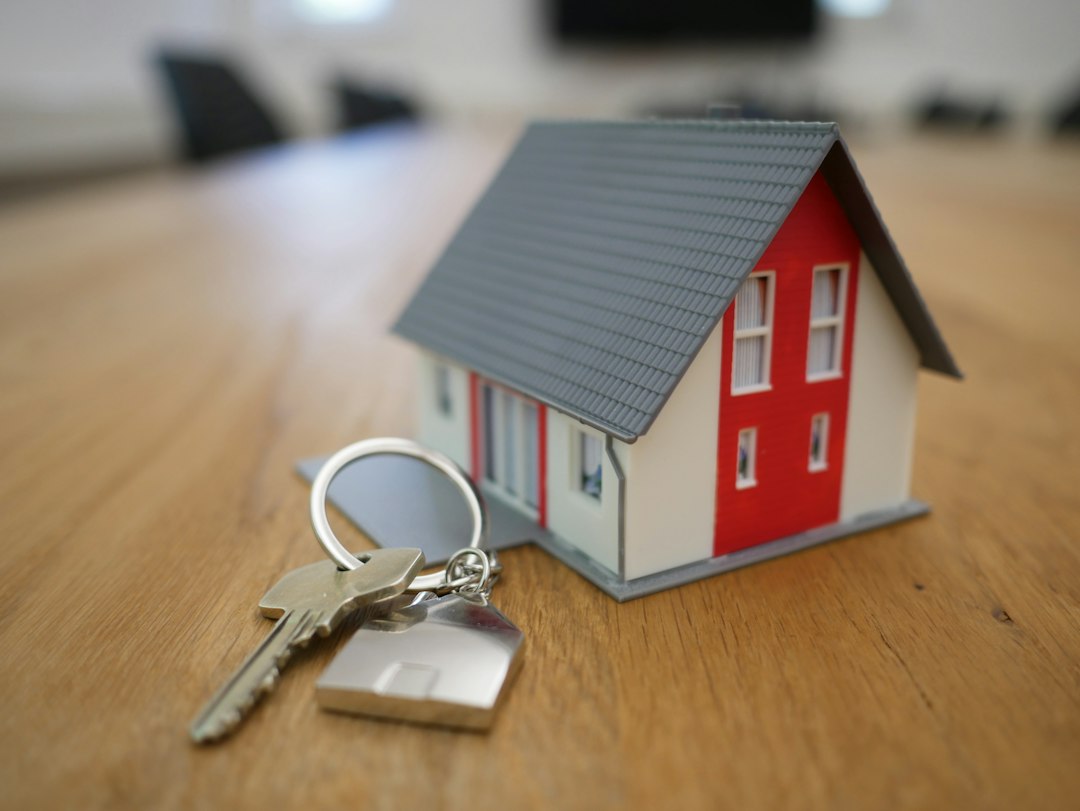 Miniatuurhuisje van wit en rood hout op een bruine tafel